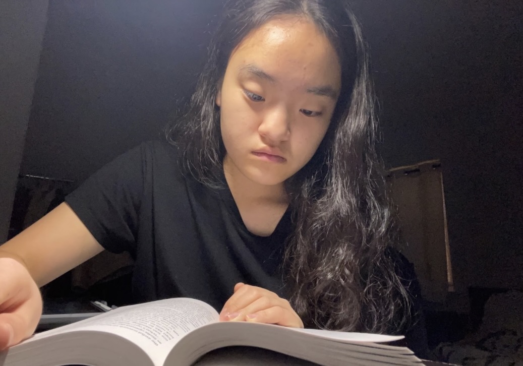 A Quiet Pre-Drawn—Sophomore Sujin Kim reading an English book under a night light in the morning before school. Despite the language barrier, she overcame the challenge. 